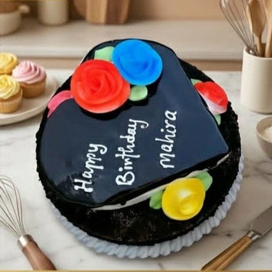 A dark chocolate cake with a glossy top panel and large red, blue and yellow piped roses around the edge